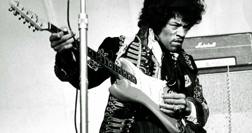 Black and white photograph of Jimi Hendrix playing the guitar in 1967